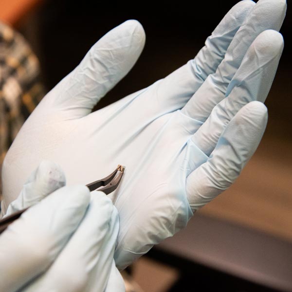 A permanent magnet displayed in a hackathon participant's gloved hand.