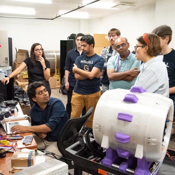 Sairam Geethanath, bottom left, seen with hackathon participants and the MRI scanner in NYU Langone's low-field laboratory.