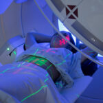 Photo: a person on a linear accelerator machine.